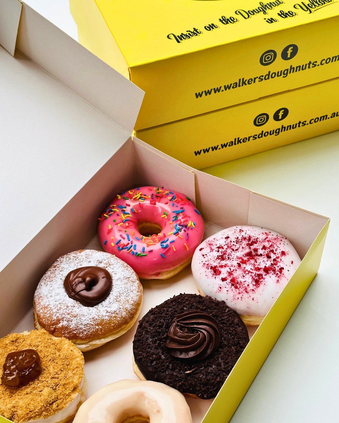 Yellow Walker's box filled with assorted fresh Doughnuts